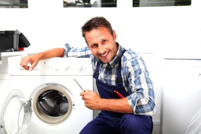 Мужчина улыбается около стиральной машинки